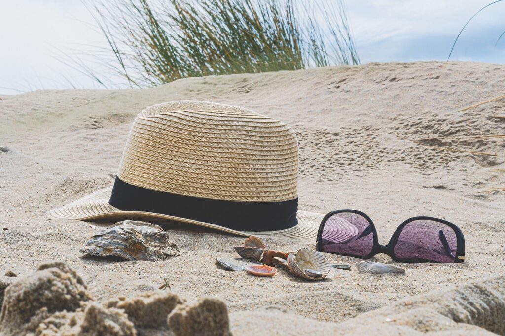 Beach hat and sunglasses resting on the sand of one of the beaches in El Nido, Palawan, Philippines.