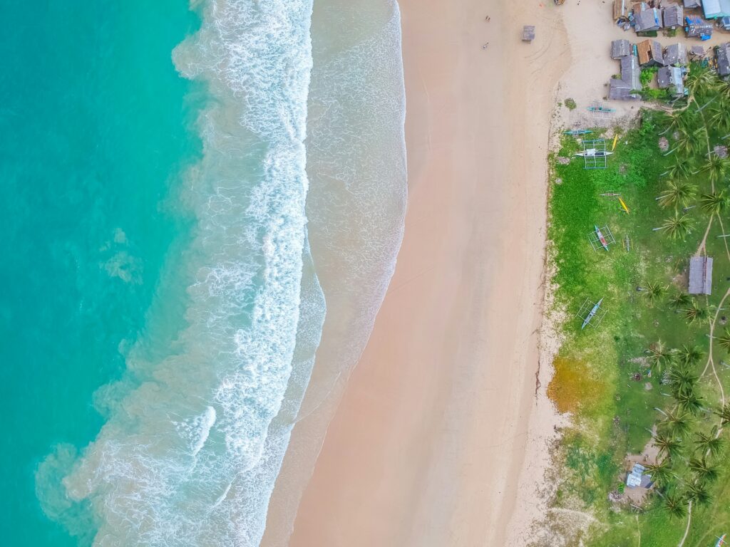 an aerial view of a crystal waters in Nacpan Beach El Nido Palawan Philippines