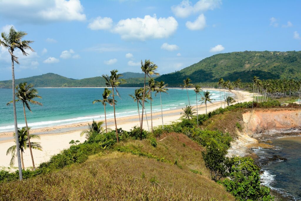 crystal waters and golden sand stretch in Nacpan Beach El Nido Palawan Philippines