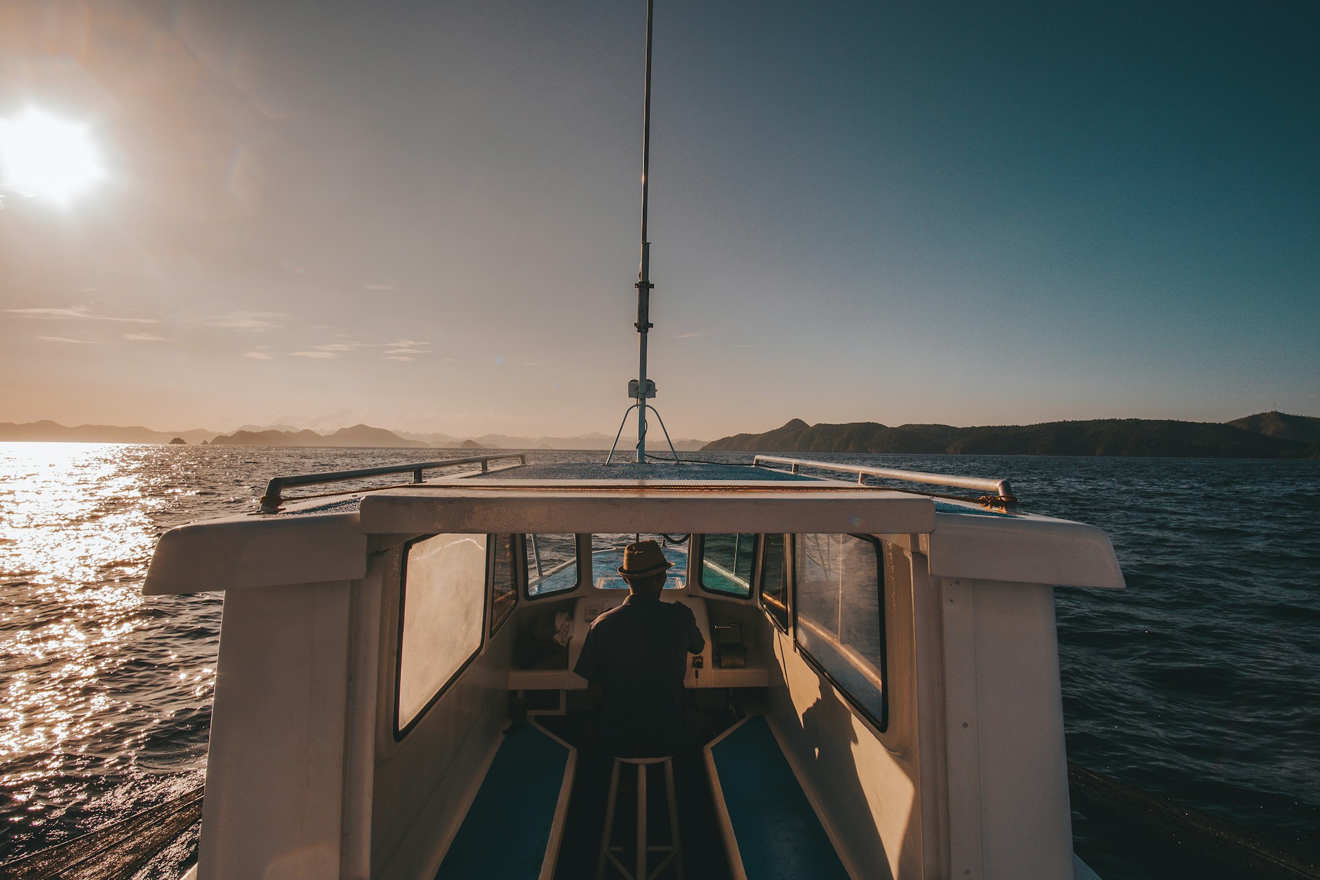 A man is riding a private yacht on a hopping island tour in Coron, Palawan, Philippines.