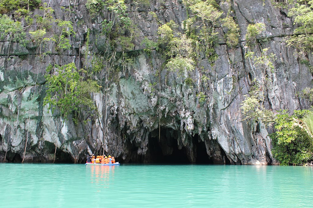 group of tourists riding a small boat entering the Puerto Princesa Underground River in Puerto Princesa Palawan Philippines