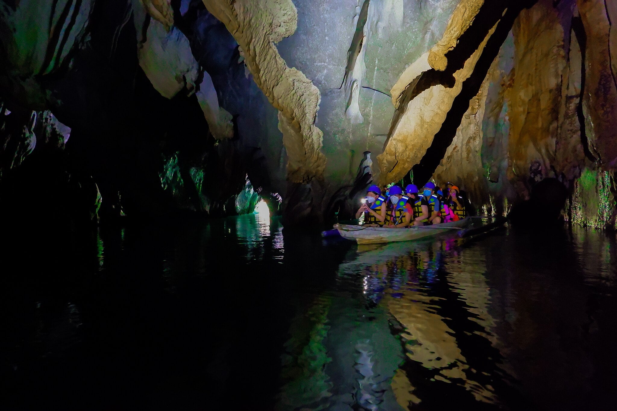 tourists riding a small boat inside the cave of St. Paul Subterranean National Park in Puerto Princesa Palawan Philippines