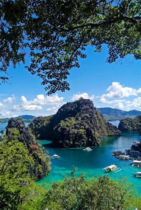 Kayangan Lake in Coron, Palawan, showcasing turquoise waters surrounded by steep limestone cliffs and lush greenery