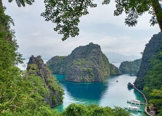 Stunning view of Kayangan Lake in Coron, Palawan, featuring crystal-clear blue waters surrounded by rugged limestone cliffs and lush vegetation