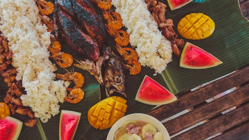 A selection of fresh seafood, including fish, and shrimp, served on banana leaves, a traditional way of presenting seafood in the Philippines