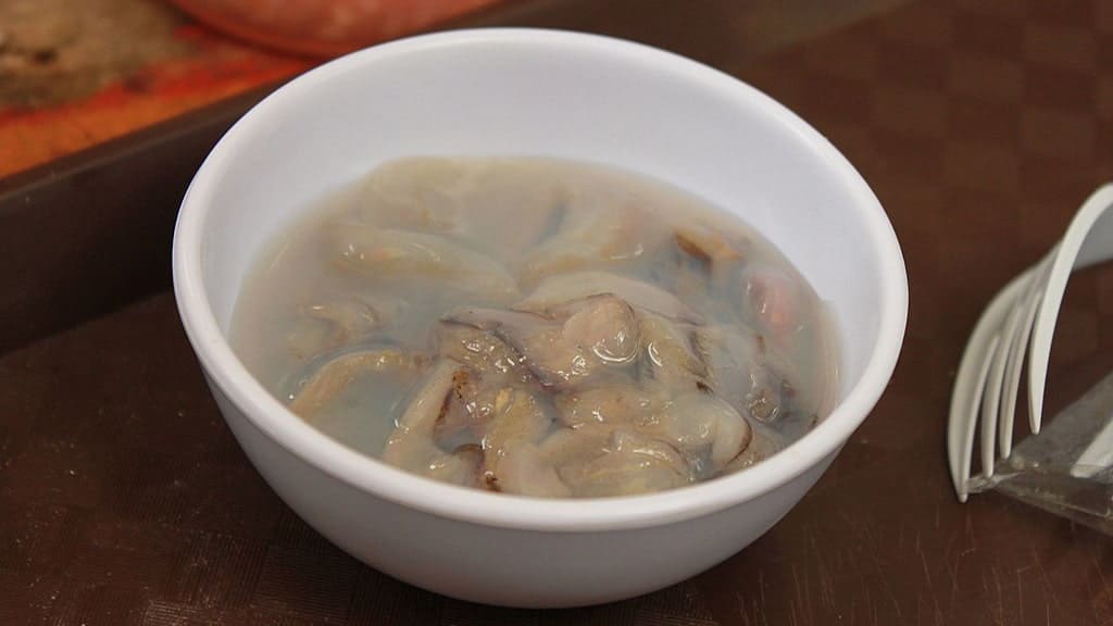 A small bowl of Tamilok (woodworm), one of the famous foods in El Nido, Palawan, served alongside other popular local seafood dishes such as fresh fish, shrimp, and crabs, showcasing the region’s rich culinary offerings